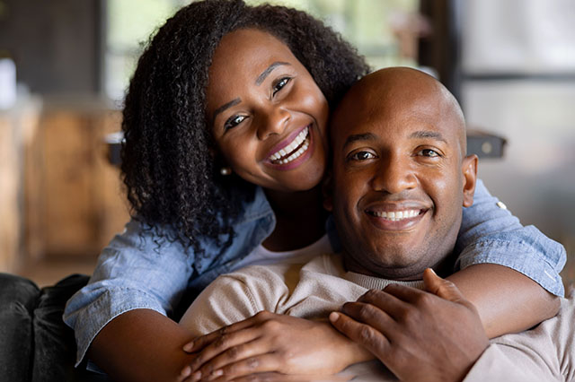 Portrait of a loving African American couple smiling at home and looking at the camera.